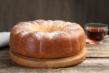 Freshly baked sponge cake and tea on wooden table, closeup