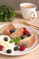 Pieces of freshly baked sponge cake, berries, ice cream, mint and coffee on wooden table, closeup