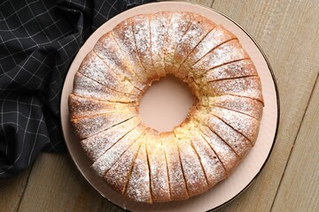 Freshly baked sponge cake on wooden table, top view