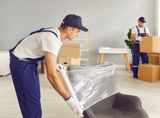 Professional delivery and moving service. Loader wraps chair with transparent stretch film while...