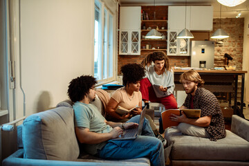 Friends studying together at home with books and laptops