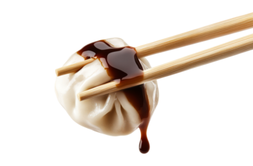 Delicious dumpling held with chopsticks, dripping soy sauce, cut out