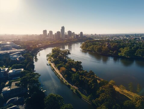 Aerial view of Parramatta river in Western Sydney. Cityscape with river meandering through center, flanked by green trees. Modern skyline visible in distance, tall building stands out against blue