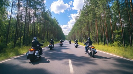 A group of motorbikes on the forest road riding. having fun driving the empty road on a motorcycle tour journey. In summer against a blue sky. Concept of motorsport, speed. Back view
