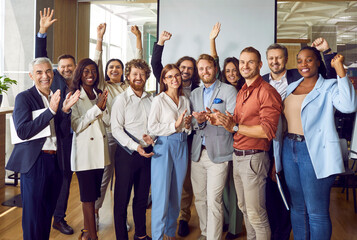Group of a business multiethnic diverse people men and women looking cheerful at camera applauding...