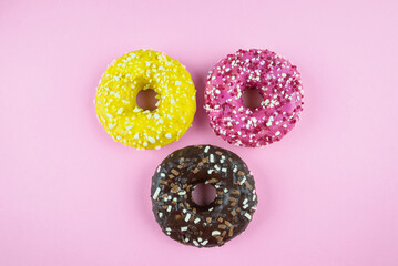 donuts on a pink background. Three red donuts on pink. Copy space.