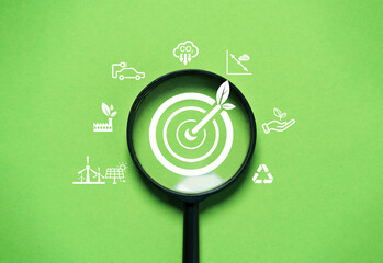 Target board with arrow inside of magnifier glass among environment icon include recycle planting...