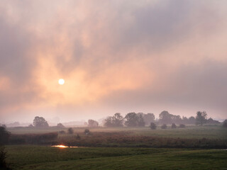 foggy early morning landscape of amerongse bovenpolder in holland at sunrise