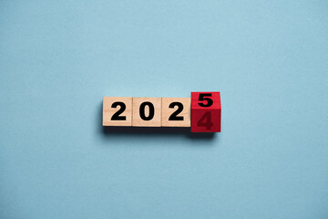 Flipping of 2024 to 2025 on wooden block cube for preparation new year change and start new...