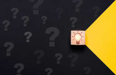 Glowing lightbulb on wooden block cube move yellow to black side with question mark for problem...