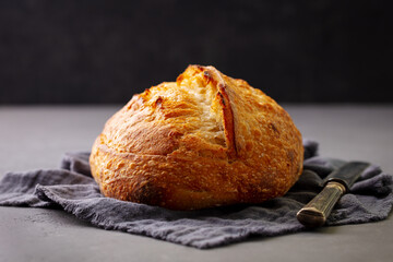 Sourdough bread on gray napkin. Dark background. Top view.