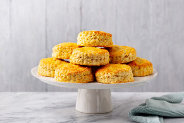 Scones, traditional British bakery on cake stand. Grey background. Close up.