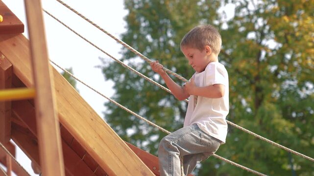 Children are climbing on a playground. Active outside sport concept. A group of kids are playing and climbing. A group of children are playing on a playground while climbing lifestyle.