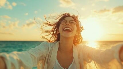 Obraz premium A woman with a radiant smile enjoying a seaside sunset, captured in a dynamic moment with windblown hair, wearing glasses, embodying freedom and joy.