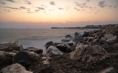 red sunset in the surf on the rocks and splashes