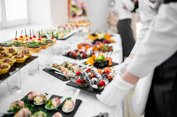 A vibrant catering table with an assortment of gourmet appetizers, elegantly presented at a formal...