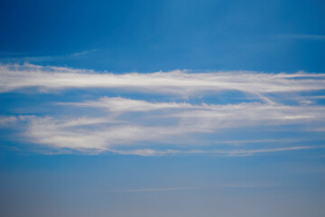 Thin stripes of white clouds in a blue sky, close-up