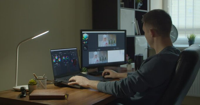 Man working on computer with Two Monitors Color Correction Post Production video or photo in Progress Closeup.