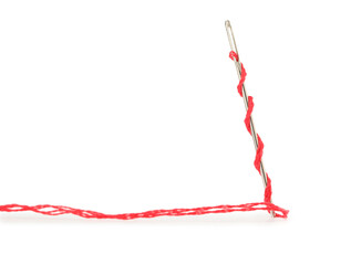Sewing needle with red thread isolated on white