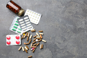 Pharmacist. Different pills and plastic bottle on grey table, flat lay. Space for text