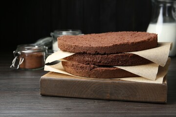 Cut chocolate sponge cake and ingredients on wooden table