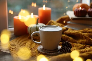 Cup of coffee, cones and soft sweater on table. Autumn atmosphere