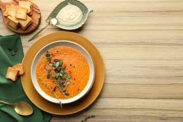 Delicious pumpkin soup with spices served on wooden table, flat lay. Space for text