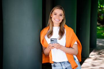 Photo of positive good mood woman dressed white t-shirt chatting modern gadget outdoors urban city...