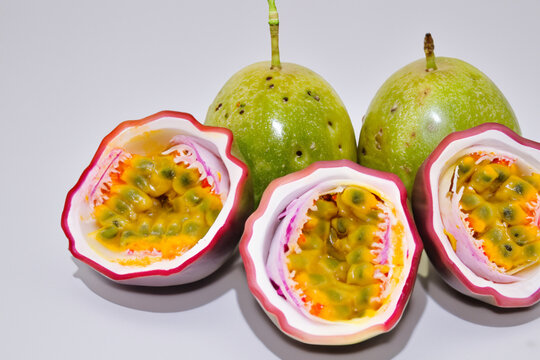 Passion fruit in gray on a. Healthy fresh sweet concept. Passion fruit in the form of halves on a gray. Passion fruit in the form of a heart shaped heart shaped heart with lifestyle gray and white.
