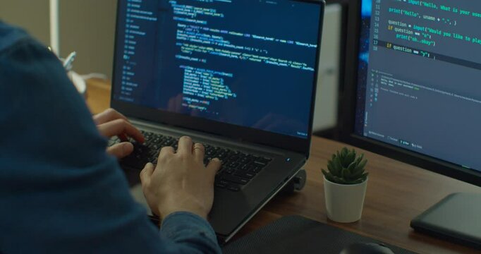 Closeup coding on screen, Man hands coding html and programming on two screen Monitors, development web, developer.