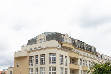 Fototapeta premium There is a large commercial building featuring numerous windows located in an urban area, and it is a cloudy day with an overcast sky