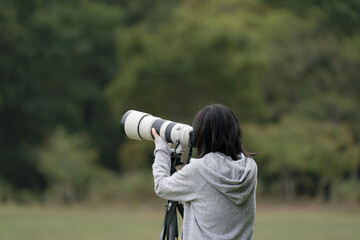 望遠レンズで写真を撮る女性, 後ろ姿