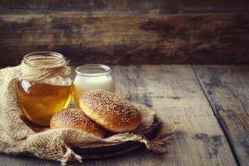 Freshly baked breakfast bread rolls arranged beautifully with a jar of honey and a bottle of milk on a rustic kitchen table. This inviting scene captures the essence of a cozy morning