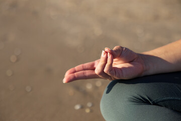 Close-up of a woman's hand showing the Prana mudra against a blurred background