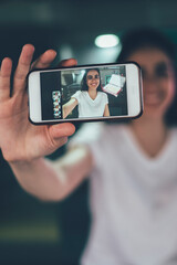 Selective focus on modern cellphone gadget holding positive millennial hipster girl, woman using main camera on smartphone device for photographing herself and attracting followers with publication