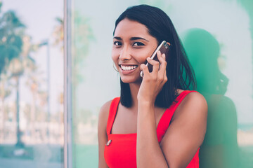 Close up portrait if cheerful Hispanic woman communicating via new smartphone application and enjoying high speed roaming connection, happy gladden woman received good news during cell talking