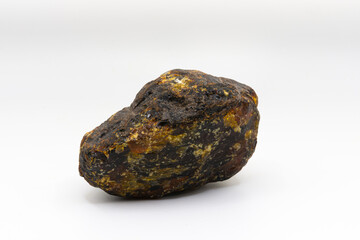 An image of a rough unpolished amber crystal on a white background.