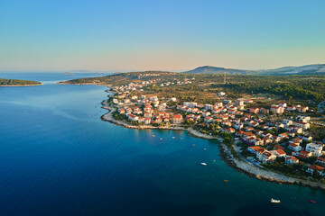 Aerial view of Adriatic sea coastline with coastal village and boats along shoreline. Panorama of tourist town Rogoznica in Croatia on Adriatic Sea. Summer travel concept