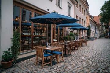 Fototapeta premium Tranquil Alfresco Dining in Historic European Setting with Cobblestone Street and Empty Chairs