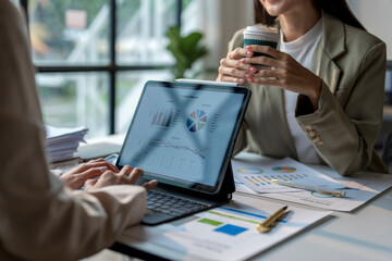 Business team analyzing financial data on tablet and discussing business strategy