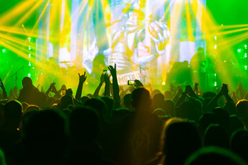 Hands holding phone and making photos on the concert.