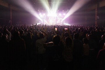 Hands holding phone and making photos on the concert.