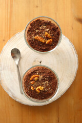 Two bowls of chia seed, chocolate and orange pudding. Healthy snack, wooden background. Top view.