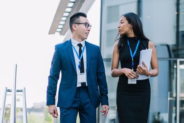 Fototapeta premium Stylish business people walking on street and talking