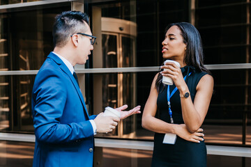 Stylish colleagues having coffee break on street