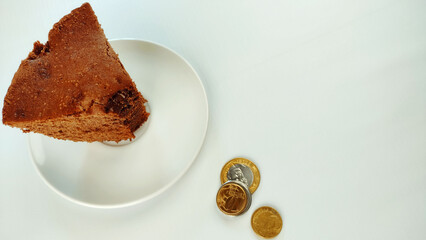 Piece of cake and some coins on the white background with copy space. Bill and payment concept