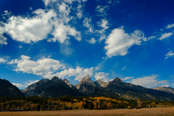 Grand Teton Mountains Tetons in Wyoming Rugged Mountain Range in Autumn Fall Landscape with blue sky and clouds