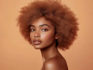 portrait of a confident black woman with a striking peach-colored afro hairstyle. warm, soft lighting enhances her radiant skin against a complementary pastel peach backdrop.