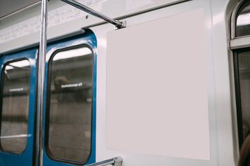 An advertising poster on the wall of a train car in the subway. Free space.
