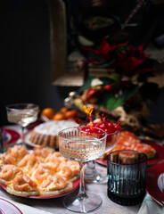 Crystal glass with Spritz cocktail on a blurred background with snacks and Christmas tree.